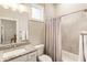 Light-filled bathroom featuring a granite countertop, white cabinetry, and tiled shower with decorative curtain at 105 Ivey Way, Woodstock, GA 30188