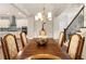 Dining room with modern chandelier, hardwood floors, and access to the kitchen and staircase at 105 Ivey Way, Woodstock, GA 30188