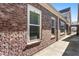 Brick exterior detail with window showing neutral trim and gated access to a courtyard at 105 Ivey Way, Woodstock, GA 30188