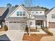 Beautiful two-story home showcasing brick accents, gray siding, manicured landscaping, and an attached two-car garage at 105 Ivey Way, Woodstock, GA 30188