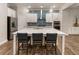 Modern kitchen features island with seating, white cabinets, stainless appliances, and blue tiled backsplash at 105 Ivey Way, Woodstock, GA 30188