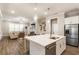 Open-concept kitchen with stainless appliances, island and a view into a spacious and adjacent living room at 105 Ivey Way, Woodstock, GA 30188