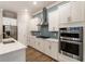 Bright kitchen features stainless steel appliances, white cabinets and a blue tile backsplash at 105 Ivey Way, Woodstock, GA 30188