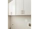 Laundry room with upper white shaker cabinets and brushed nickel hardware provides storage for your cleaning supplies at 105 Ivey Way, Woodstock, GA 30188