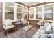 Cozy sunroom with brick wall, comfortable seating, and ample natural light at 105 Ivey Way, Woodstock, GA 30188