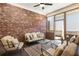 Cozy screened-in porch with brick wall, stylish furniture, and ceiling fan at 105 Ivey Way, Woodstock, GA 30188