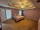 Bedroom featuring tray ceilings, a ceiling fan, and a door that leads to the backyard at 165 Shiver Blvd, Covington, GA 30016