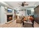 Living room with lit fireplace, wood floors, and ceiling fan at 3255 Aldrich Dr, Cumming, GA 30040