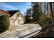 View of the driveway and side of house showing a basketball hoop and well maintained landscaping at 5443 Dunwoody Knoll Ct, Dunwoody, GA 30338