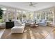 Sunroom living area with large windows, neutral colors, and comfortable seating for relaxing and entertaining at 5443 Dunwoody Knoll Ct, Dunwoody, GA 30338