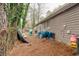 Exterior shot of a home's backyard, showing the side of the house and a yard area covered in pine straw at 5461 Chuzzlewit Sw Ct, Lilburn, GA 30047