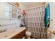 Modest bathroom featuring a vanity with white countertop, and a shower with a patterned curtain at 5461 Chuzzlewit Sw Ct, Lilburn, GA 30047