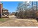 Large fenced backyard with mature trees and distant view of neighboring houses at 3000 Shade Tree Ct, Villa Rica, GA 30180