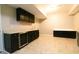 Finished basement featuring dark cabinets, sink, and light tile flooring at 8245 Mill Run Trl, Whitesburg, GA 30185