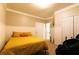 Cozy bedroom with a comfortable yellow bed, two closets and access to the bathroom at 8245 Mill Run Trl, Whitesburg, GA 30185