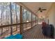 Covered patio overlooking scenic woodland, featuring ceiling fans and wood flooring at 8245 Mill Run Trl, Whitesburg, GA 30185