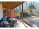 Covered patio with seating area, view of wooded backyard with privacy fence at 8245 Mill Run Trl, Whitesburg, GA 30185