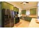Bright kitchen offers stainless steel appliances, ample counter space, and custom green cabinetry at 8245 Mill Run Trl, Whitesburg, GA 30185