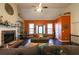 Inviting living room featuring a stone fireplace, vaulted ceilings, and abundant natural light at 8245 Mill Run Trl, Whitesburg, GA 30185