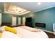 Large main bedroom with tray ceiling with doors, large TV, and modern decor at 8245 Mill Run Trl, Whitesburg, GA 30185