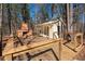 Outdoor structure with a deck, fireplace, and serene views of nature at 8245 Mill Run Trl, Whitesburg, GA 30185