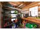 Well-organized shed with shelving units, gardening supplies, and natural light from a window at 8245 Mill Run Trl, Whitesburg, GA 30185