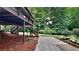 Multi-tiered deck and stairs lead to a backyard with mature trees, shrubbery, and a wooded area at 225 Powder Creek Dr, Dallas, GA 30157