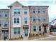 Charming, new brick townhome featuring a covered entryway and beautifully landscaped front yard at 3255 Bartee Walk, Suwanee, GA 30024