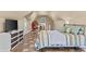 Spacious bedroom with sloped ceilings, featuring a comfortable bed, TV, and an egg chair with a view at 212 Lakeview Dr, Newborn, GA 30056
