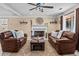 Bright living room featuring two leather sofas, a fireplace, and a ceiling fan at 212 Lakeview Dr, Newborn, GA 30056