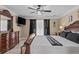 Elegant main bedroom featuring a ceiling fan, ensuite bathroom, and a dresser with a mirror and TV at 212 Lakeview Dr, Newborn, GA 30056