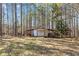 Outbuilding/shed with roll up door surrounded by trees and lawn at 212 Lakeview Dr, Newborn, GA 30056