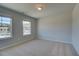This bedroom has neutral carpet and two windows offering views of the surroundings at 128 Dalston Cv, Stockbridge, GA 30281