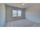 Bedroom featuring neutral carpet and two windows for natural light and views at 128 Dalston Cv, Stockbridge, GA 30281