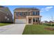 Inviting two-story brick home with a two-car garage, covered porch, and manicured lawn at 128 Dalston Cv, Stockbridge, GA 30281