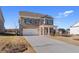 Well-manicured two-story brick home with a two-car garage, covered porch, and landscaped front yard at 128 Dalston Cv, Stockbridge, GA 30281