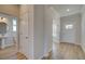 Hallway with wood-look flooring leading to a bathroom and other rooms, showcasing the home's layout at 128 Dalston Cv, Stockbridge, GA 30281