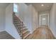 Hallway with wood-look floors, a staircase with metal spindles, and a view of the front door at 128 Dalston Cv, Stockbridge, GA 30281