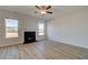 Open living room featuring wood-look floors, a fireplace, and large windows, creating a cozy atmosphere at 128 Dalston Cv, Stockbridge, GA 30281