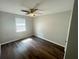 Bright bedroom with dark wood floors, ceiling fan, and white trim; the window offers a view of the outdoors at 5642 Feldwood Rd, Atlanta, GA 30349