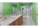Bathroom featuring double sinks, granite counters, walk-in shower, and tiled floors at 709 Mohansic Ave, Loganville, GA 30052