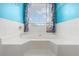 Close up of the bathtub, which has blue accent wall and curtains at 709 Mohansic Ave, Loganville, GA 30052