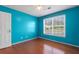 Comfortable bedroom with hardwood floors, a ceiling fan, and natural light from a large window at 709 Mohansic Ave, Loganville, GA 30052