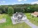 Inviting two-story home with a well-manicured lawn and a basketball court is nestled in a serene wooded setting at 709 Mohansic Ave, Loganville, GA 30052