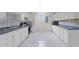 Bright kitchen features white cabinets and appliances, and a window providing natural light at 709 Mohansic Ave, Loganville, GA 30052