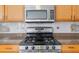 Gas range and stainless steel microwave enhance this kitchen with light wood cabinets, perfect for culinary enthusiasts at 709 Mohansic Ave, Loganville, GA 30052