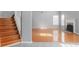 Bright living room featuring hardwood floors, a cozy fireplace, and a staircase, perfect for Gathering gatherings at 709 Mohansic Ave, Loganville, GA 30052
