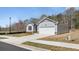 Single-story home with a two-car garage, gray siding, and a concrete driveway at 8592 Secretariat Dr, Lithonia, GA 30058