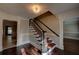 Welcoming foyer with hardwood floors, staircase with carpet runner, and elegant light fixture at 1261 William Robert Sw Dr, Marietta, GA 30008