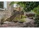 Landscaped backyard features stairs, a stone wall, and a variety of plants and trees at 229 Dovecrest Nw Dr, Atlanta, GA 30305